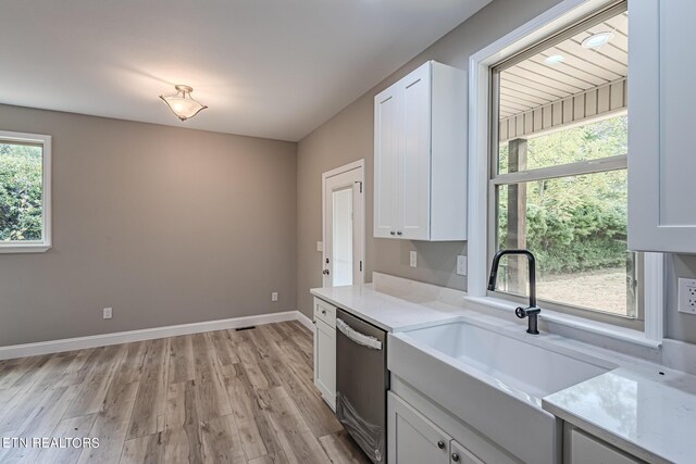 kitchen featuring white cabinetry, sink, stainless steel dishwasher, and light wood-type flooring