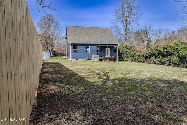 rear view of house featuring a shingled roof, central air condition unit, a lawn, and crawl space