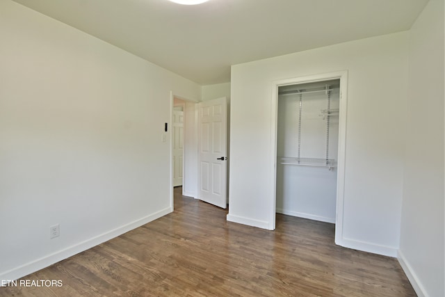 unfurnished bedroom featuring a closet and dark hardwood / wood-style floors