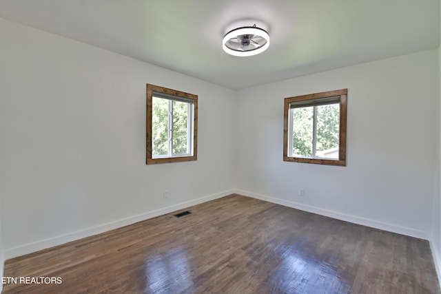 empty room featuring dark hardwood / wood-style flooring and a healthy amount of sunlight