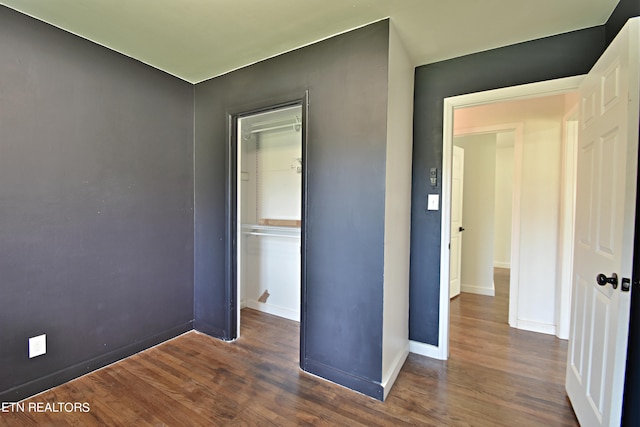 unfurnished bedroom featuring a closet and dark hardwood / wood-style floors