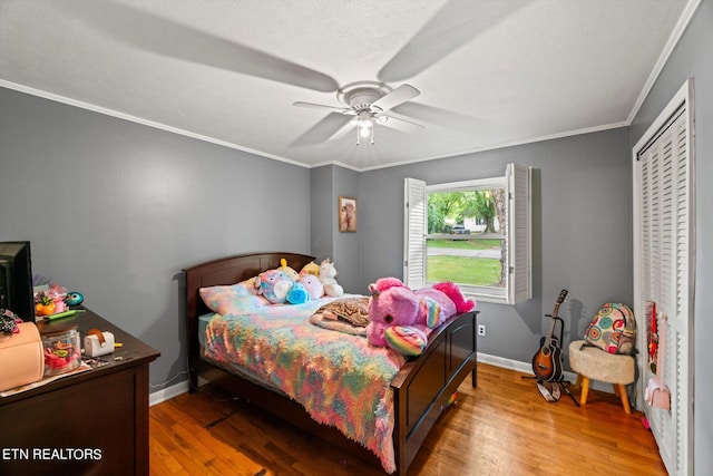 bedroom with ceiling fan, hardwood / wood-style flooring, and crown molding