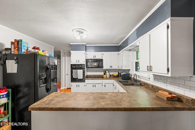 kitchen featuring black appliances, sink, kitchen peninsula, white cabinetry, and decorative backsplash