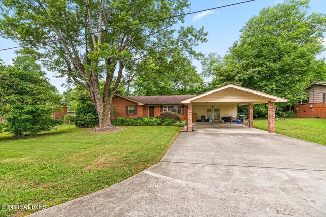 ranch-style house featuring a carport and a front yard