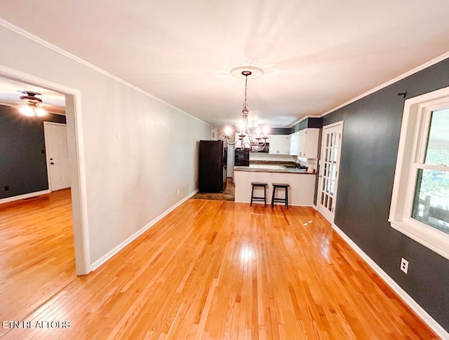 unfurnished dining area featuring light hardwood / wood-style floors, a notable chandelier, and crown molding