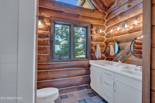 bathroom with tile patterned flooring, toilet, rustic walls, and vanity