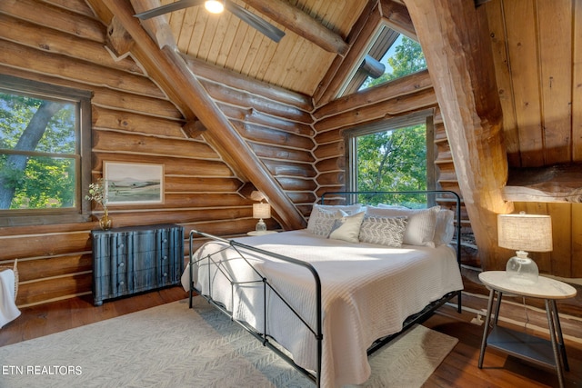 bedroom with hardwood / wood-style flooring, beam ceiling, log walls, and wood ceiling