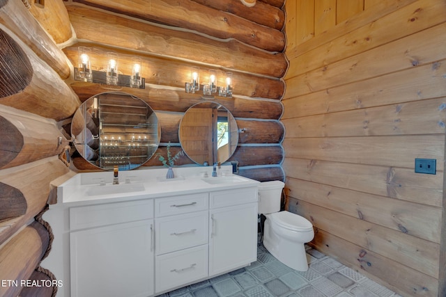 bathroom featuring tile patterned flooring, toilet, rustic walls, and vanity