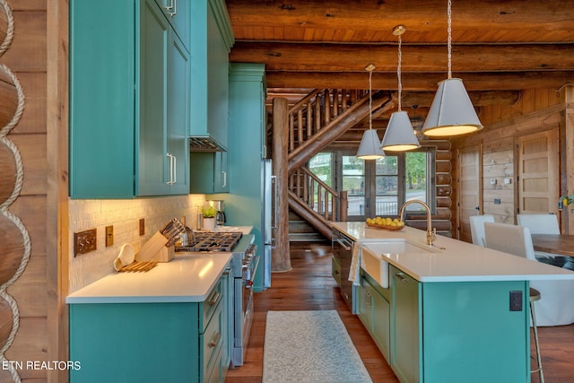 kitchen with decorative light fixtures, dark hardwood / wood-style floors, high end stainless steel range, beamed ceiling, and a kitchen island with sink