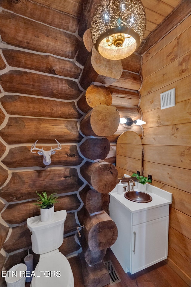 bathroom featuring wood walls, hardwood / wood-style flooring, vanity, wood ceiling, and toilet