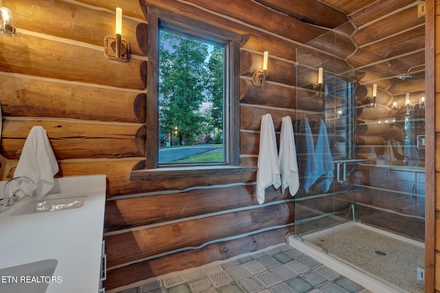 bathroom with log walls, vanity, a shower with door, and tile patterned floors