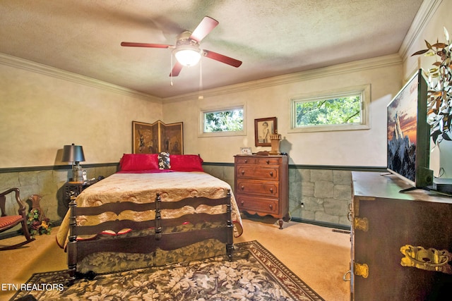 bedroom featuring ceiling fan, ornamental molding, a textured ceiling, and light colored carpet