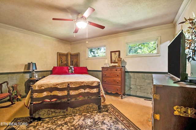 bedroom with a textured ceiling, crown molding, carpet, and ceiling fan