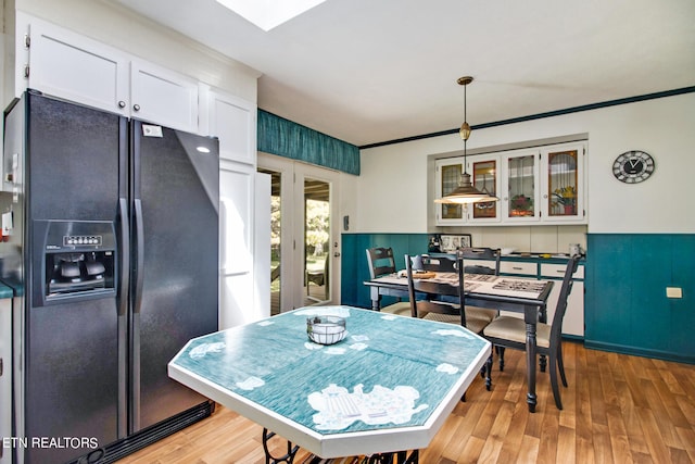 dining area featuring ornamental molding and light hardwood / wood-style floors