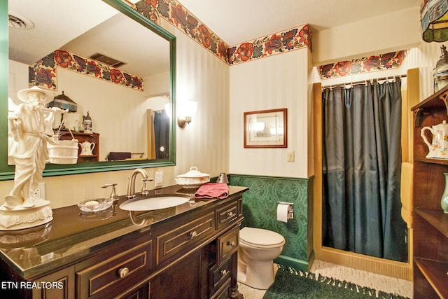 bathroom with curtained shower, vanity, and toilet