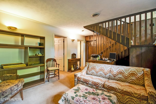 living room with ornamental molding, light carpet, wooden walls, and a textured ceiling