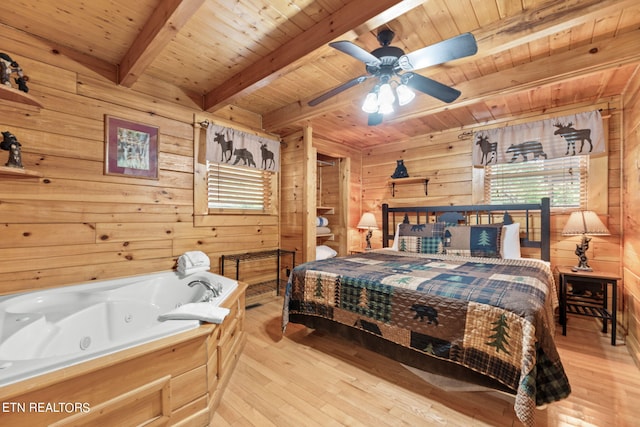 bedroom with beam ceiling, wood walls, light hardwood / wood-style floors, and wooden ceiling