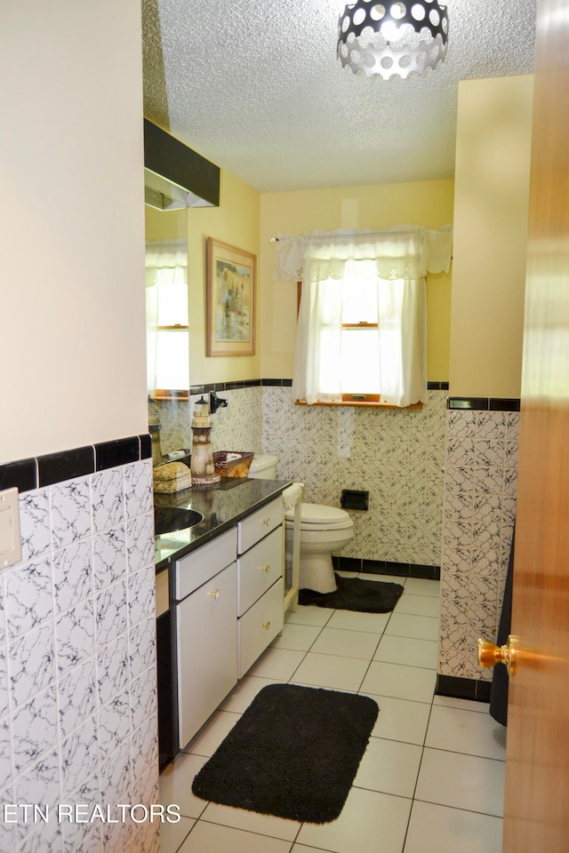 kitchen with light tile patterned floors, a wealth of natural light, and a textured ceiling