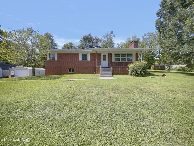 single story home featuring a front lawn and a shed