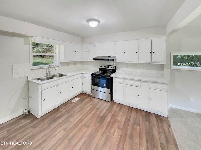 kitchen featuring sink, backsplash, light hardwood / wood-style flooring, and electric range