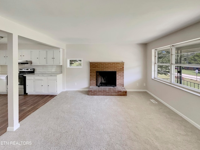 unfurnished living room featuring carpet and a fireplace