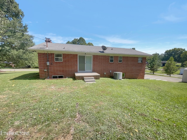 back of property featuring central AC and a lawn