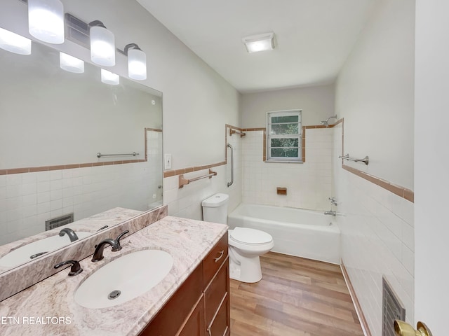 full bathroom featuring vanity, tile walls, toilet, tiled shower / bath combo, and hardwood / wood-style flooring