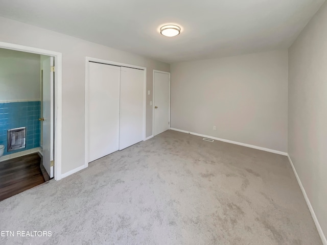 unfurnished bedroom featuring connected bathroom and carpet flooring