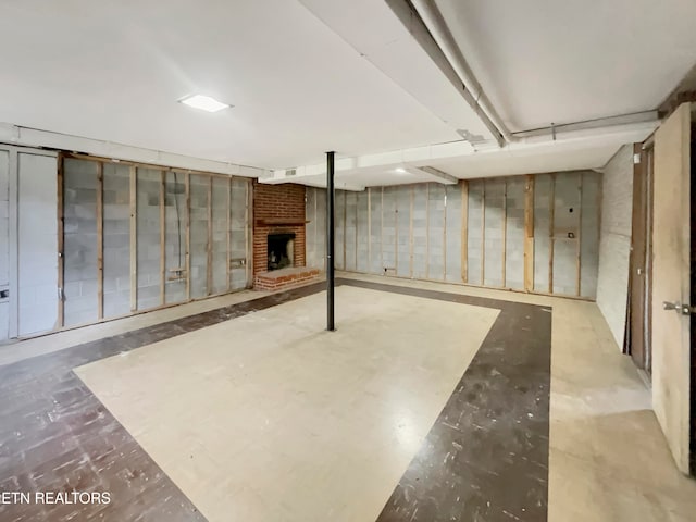 basement featuring a brick fireplace and brick wall