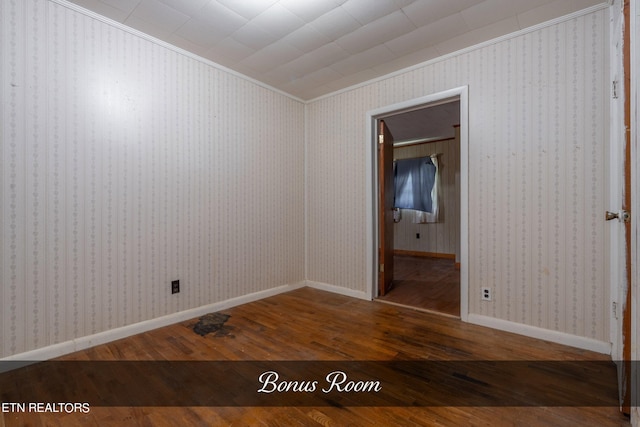 empty room featuring hardwood / wood-style flooring and crown molding