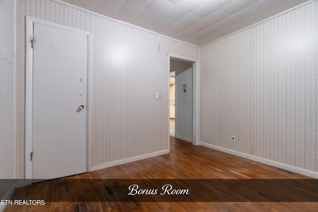 unfurnished bedroom featuring crown molding and wood-type flooring