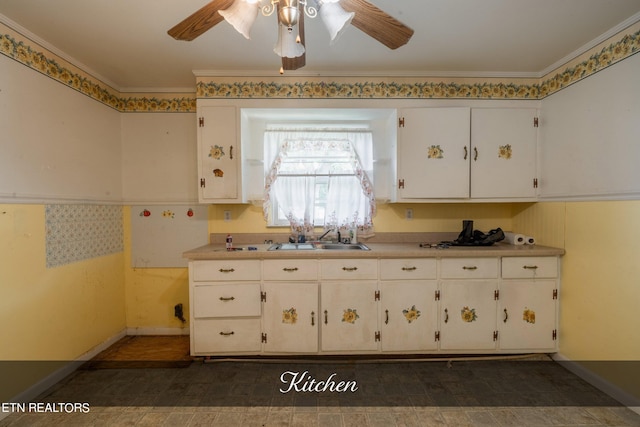 kitchen with ceiling fan, sink, white cabinetry, and ornamental molding