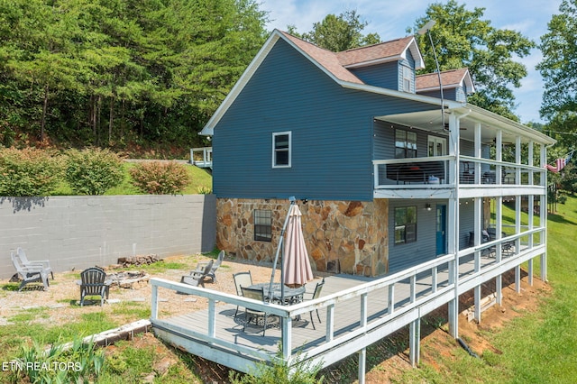 view of side of home featuring a deck and a fire pit