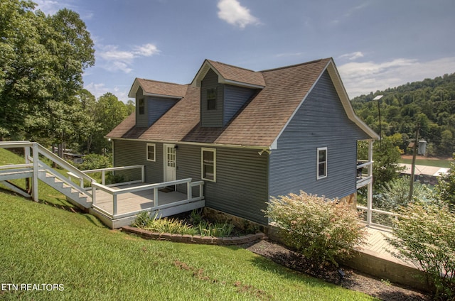 exterior space featuring a front lawn and a wooden deck