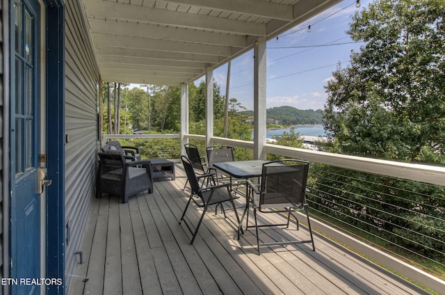 wooden terrace featuring a water view