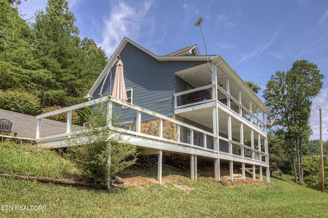 view of side of home with a yard and a balcony