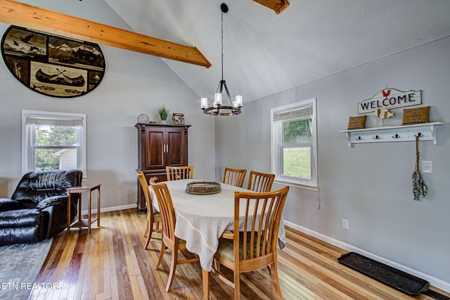 dining space with vaulted ceiling with beams, plenty of natural light, and light hardwood / wood-style flooring