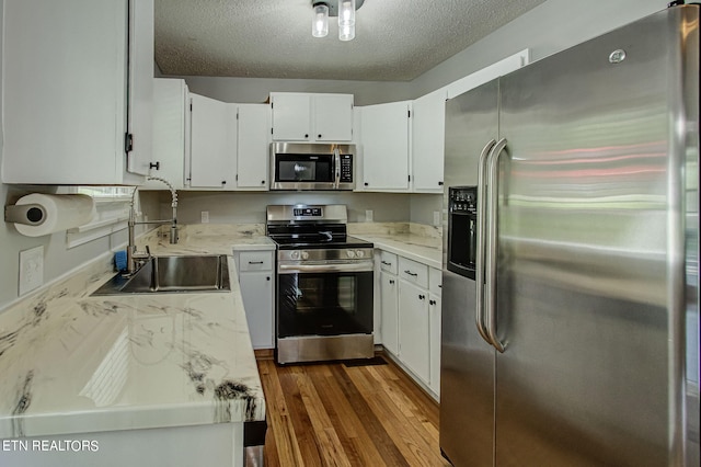 kitchen with sink, stainless steel appliances, dark wood-type flooring, and white cabinets