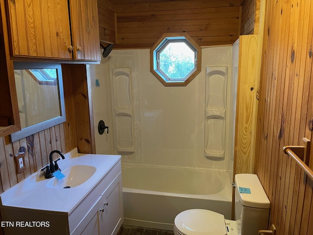 bathroom with toilet, wood walls, bathing tub / shower combination, and vanity