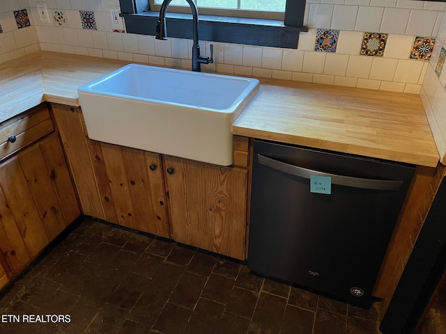 kitchen featuring brown cabinetry, a sink, dishwashing machine, and tasteful backsplash