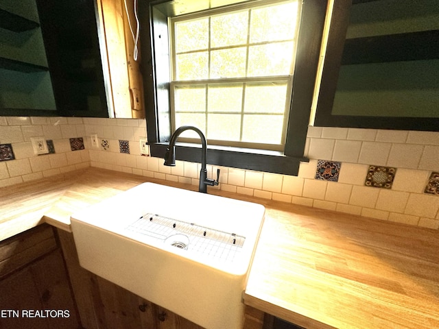 details with open shelves, a sink, backsplash, and light countertops