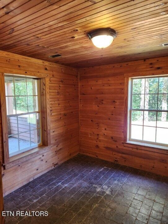 spare room with wooden ceiling and wood walls