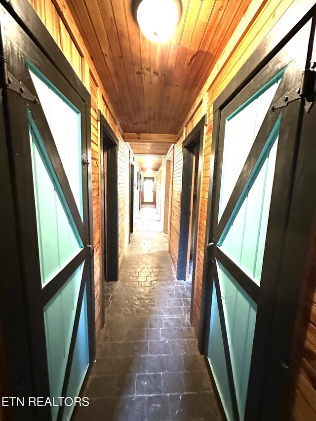 hall with wooden ceiling and wood walls