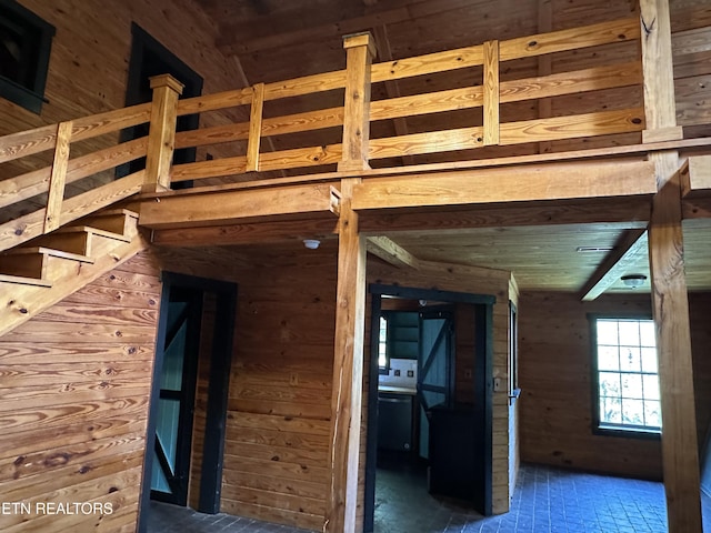 interior space with wood walls and brick floor