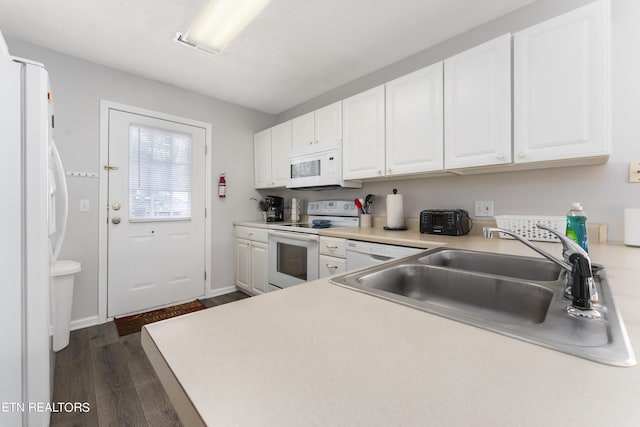 kitchen with sink, white cabinets, dark wood-type flooring, and white appliances