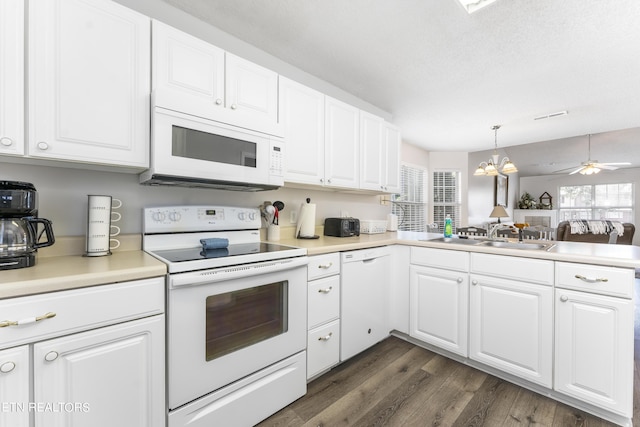 kitchen featuring sink, white cabinets, decorative light fixtures, and white appliances