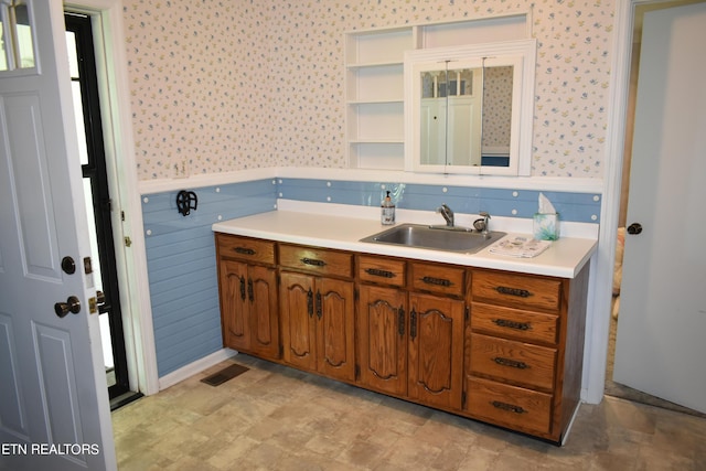 bathroom with wainscoting, visible vents, vanity, and wallpapered walls