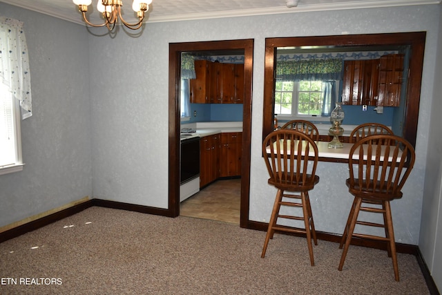 dining space with ornamental molding, a chandelier, light carpet, and baseboards