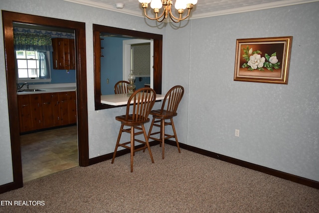 dining room with a chandelier, carpet floors, baseboards, and crown molding