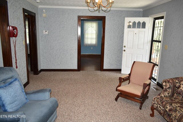 sitting room with a chandelier, crown molding, and carpet